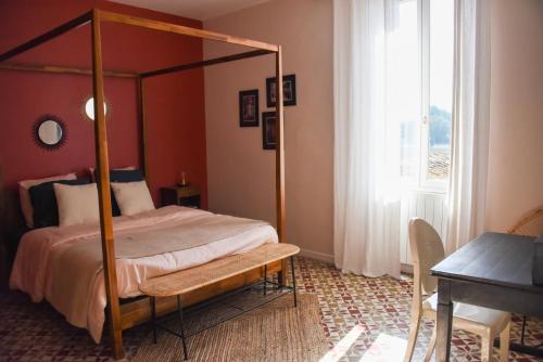 Schlafzimmer mit einem Bett, einem Tisch und einem Fenster in der Unterkunft Mas Gardane in Pernes-les-Fontaines