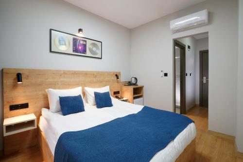 a bedroom with a large bed with a blue blanket at Meet İstanbul Hotel Kadikoy in Istanbul
