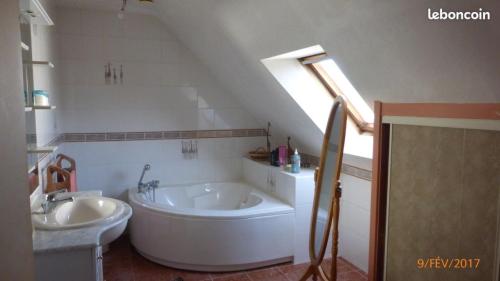 La salle de bains est pourvue d'une grande baignoire et d'un lavabo. dans l'établissement La palette - Maison vue sur mer, à Saint-Gildas-de-Rhuys