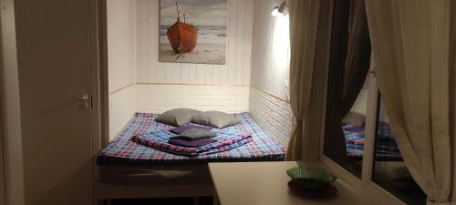 een kleine kamer met een bed met kussens erop bij Laulasmaa Sleeps in Laulasmaa