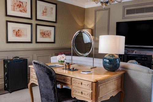 a living room with a table and a mirror at Althoff St James's Hotel & Club London in London