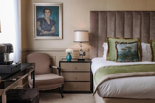 een slaapkamer met een bed, een bureau en een stoel bij Althoff St James's Hotel & Club London in Londen