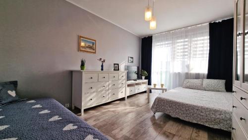 sypialnia z 2 łóżkami i komodą w obiekcie Przystań Bałtyk Apartment w Gdańsku