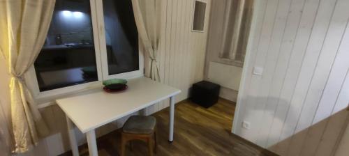 een kleine witte tafel in een kamer met een raam bij Laulasmaa Sleeps in Laulasmaa