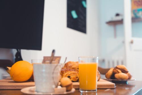 - une table avec un verre de jus d'orange et du pain dans l'établissement Agréable T2 - Jardin botanique, à Tours