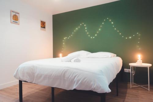 un lit avec une tête de lit éclairée dans l'établissement Agréable T2 - Jardin botanique, à Tours