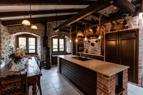 a kitchen with an island in a brick wall at Talići Hill - Rustic Villas in Sutomore