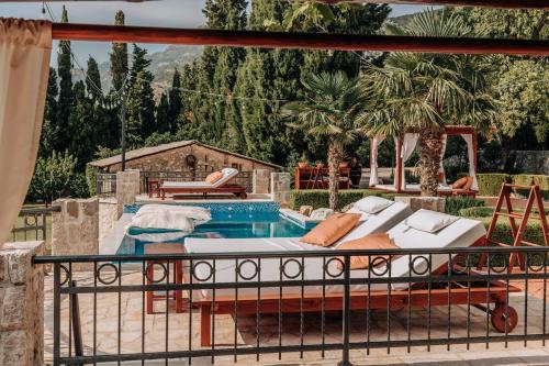 a pool with a bed next to a swimming pool at Talići Hill - Rustic Villas in Sutomore