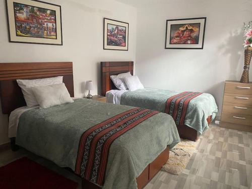 a hotel room with two beds and a dresser at New Apartment in Historic City Center in Cusco