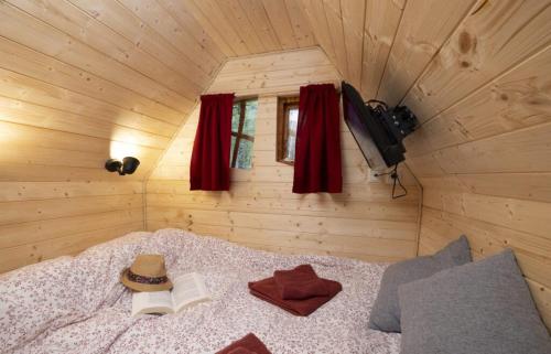 a bedroom with a bed with a hat and books at Camping USHUAÏA Villages Au Bois Joli in Andryes