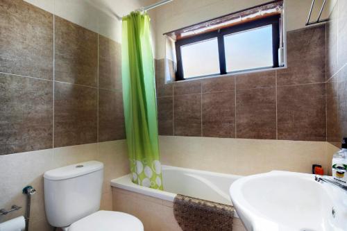 ein Badezimmer mit Toilette und Waschbecken und einem Fenster in der Unterkunft A O - Augusta in Peniche