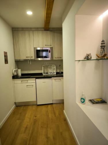 uma cozinha com armários brancos e um micro-ondas em Coimbra downtown studio em Coimbra