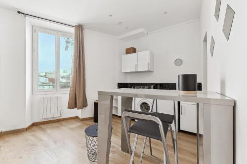 - une cuisine blanche avec une table et une chaise dans l'établissement La Pépite de la Joliette - Central & Lumineux - Les Frères de la Loc', à Marseille