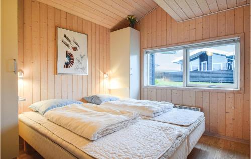a bedroom with a large bed with a window at Søhus in Fæbæk