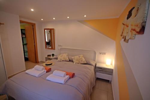 1 dormitorio con 1 cama con toallas en wunderschönes kleines Apartment für 2 Personen mit idylischen Blick ins Grüne, en Cala Galdana