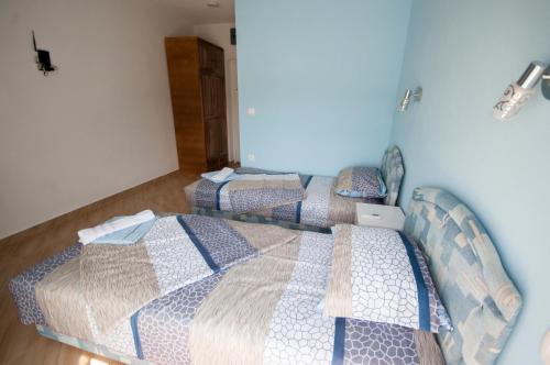 two twin beds in a room with blue walls at Studio Apartments Tea in Sutomore