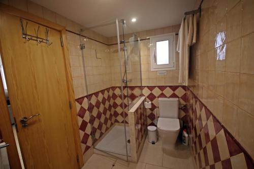 a bathroom with a toilet and a glass shower at wunderschönes kleines Apartment für 2 Personen mit idylischen Blick ins Grüne in Cala Galdana