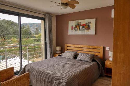 a bedroom with a bed and a large window at Souleia in Oppède