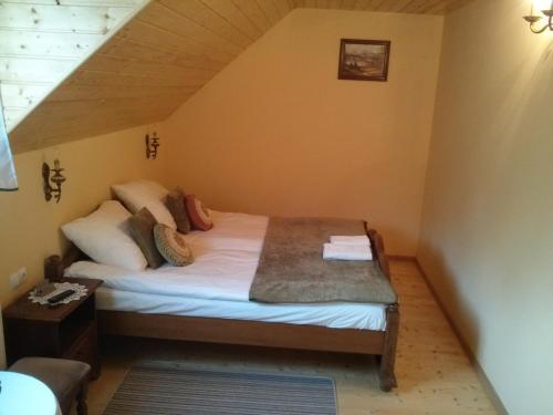a small bedroom with a bed in a attic at Zbójna Debra in Golejów