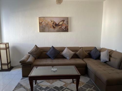 a living room with a brown couch and a table at Apartment in the City Center Neama Bay and free Wi-Fi in Sharm El Sheikh