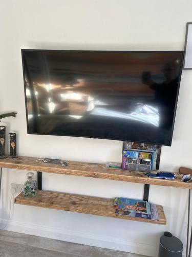 a flat screen tv on a wooden shelf at Lily Bank Room in Stonehaven