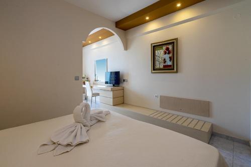 a bedroom with a large white bed and a desk at Kamari Beach in Lardos