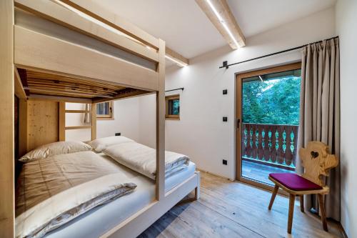a bedroom with a bed and a large window at Bergchalet Lanthalerhof in San Martino