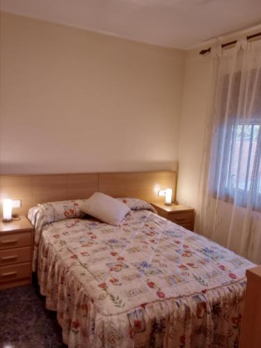 ein Schlafzimmer mit einem Bett mit zwei Nachttischen und zwei Lampen in der Unterkunft Casa en Barcelona in Papiol