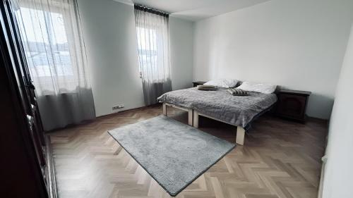 a white room with a bed and a rug at Parkside Apartments Praha in Prague