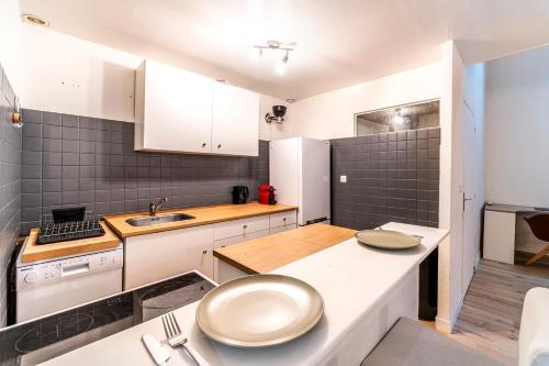 une cuisine avec des armoires blanches et un comptoir dans l'établissement Ravissante Maison Coeur de Lille, à Lille