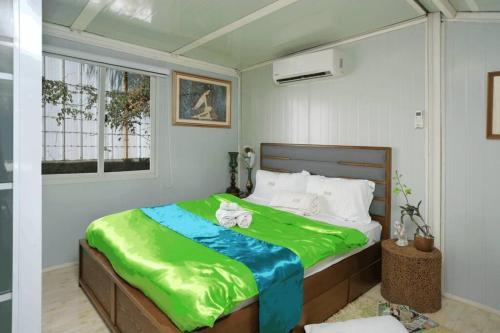 um quarto com uma cama grande e um cobertor verde em Golden V Grandeuria Unit F em Malolos