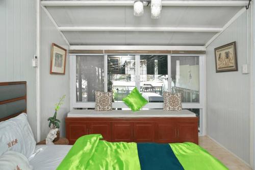 a living room with a bed and a window at Golden V Grandeuria Unit F in Malolos