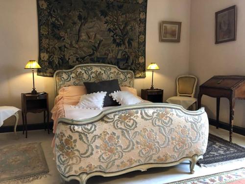 a bedroom with a large bed and a tapestry at LA FERME DU PAVILLON in Sainte-Croix-du-Mont
