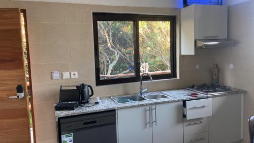 a small kitchen with a sink and a window at House 16 - Kweli and Kael in Chavanine