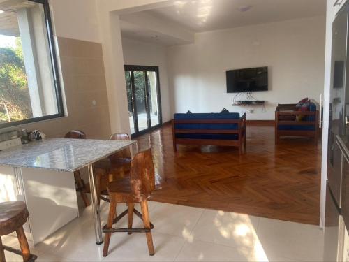 uma cozinha e sala de estar com mesa e cadeiras em House 16 - Kweli and Kael em Chavanine