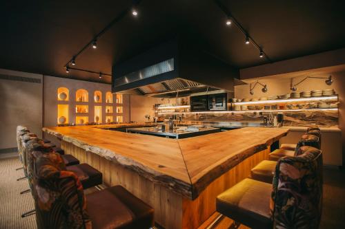 a large kitchen with a large wooden bar with chairs at Torel Palace Lisbon in Lisbon