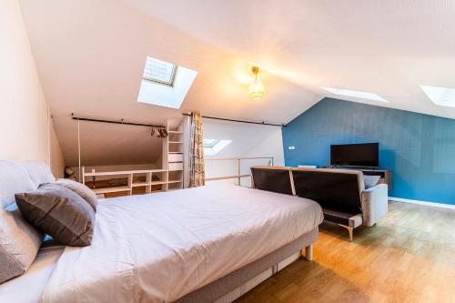 une chambre avec un lit, un bureau et une télévision dans l'établissement Ravissante Maison Coeur de Lille, à Lille