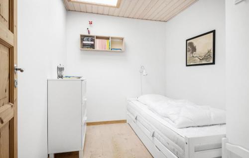 a white bedroom with a bed and a refrigerator at Gorgeous Home In Karrebæksminde in Karrebæksminde