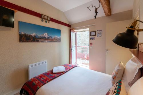 a bedroom with a bed and a window at Hotel Le Ranch in Brûlon