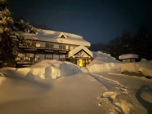 a house covered in snow at night at ALBERGO DEL PESCATORE in Minamiaizu