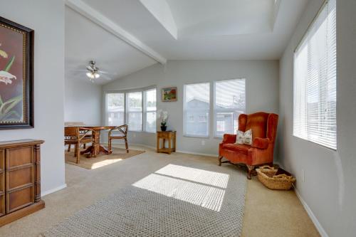 a living room with a red chair and a table at Oak View Home - Close to Beaches and Trails! in Oak View