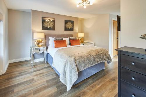 a bedroom with a large bed with orange pillows at Host & Stay - Baxtergate Apartments in Whitby