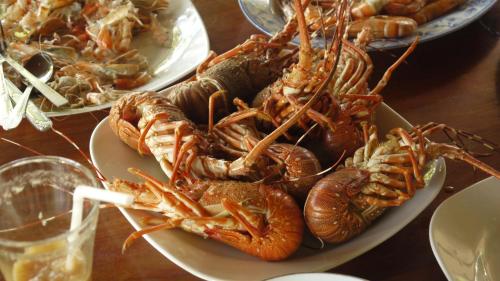 a plate of lobsters on a table with other plates of food at Traveller's Home Hotel in Tissamaharama