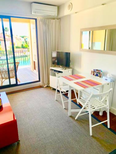 un salon avec une table et des chaises blanches dans l'établissement Terrasse ensoleillée sur les canaux, à Grimaud