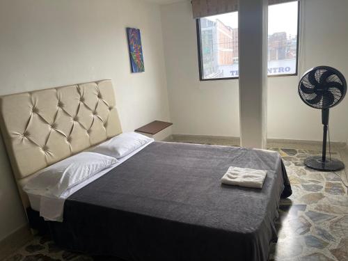 a bedroom with a bed and a fan at Apartamento cómodo , grande , céntrico , bien ubicado apto 303 in Medellín