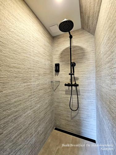 a shower with a shower head in a bathroom at De Stadsboerderij in Kampen