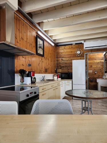 une cuisine avec une table et un réfrigérateur dans l'établissement Détendez-vous à Montverdun, à Montverdun