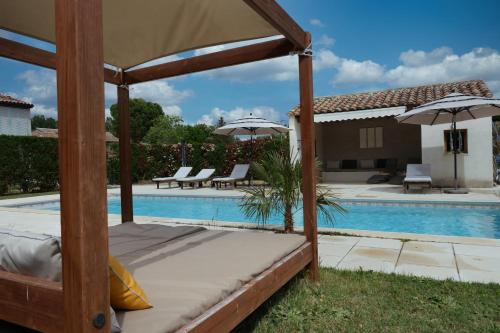 - un lit à baldaquin à côté de la piscine dans l'établissement Souleia, à Oppède