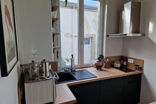 d'une cuisine avec un comptoir, un évier et une fenêtre. dans l'établissement Le Pavillon Lorrain, à Vittel