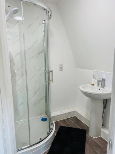 Cozy Studio in Maidstone Town Centre في Kent: حمام مع دش زجاجي ومغسلة